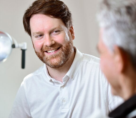 Der Berliner Zahnarzt Dr. Caemmerer im Gespräch mit einem Patienten.