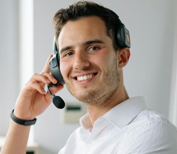 Mann mit Headset sitzt am Computer.