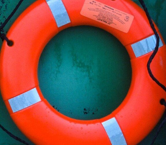 Ein Lebensretter vor einem großen Schiff.