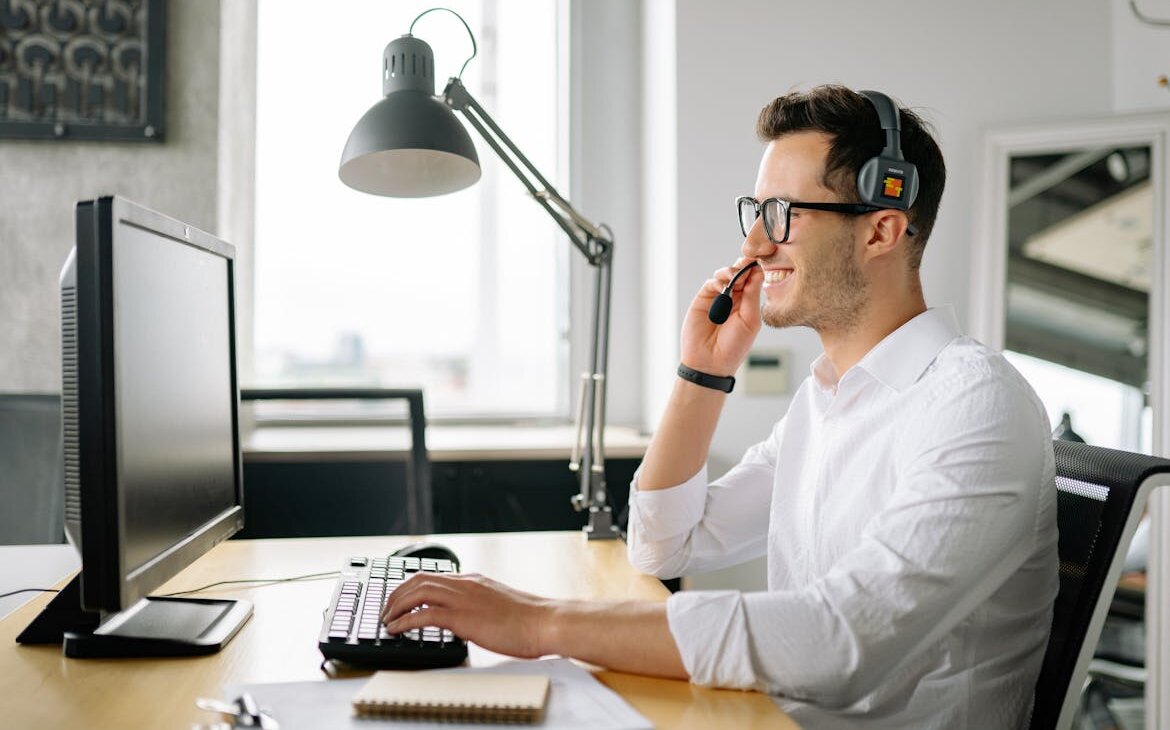 Mann mit Headset sitzt am PC.