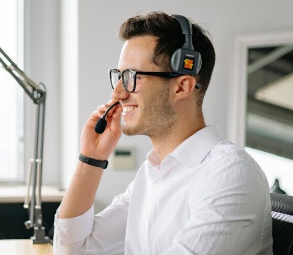 Mann mit Headset sitzt am PC.