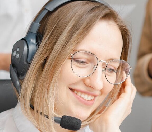 Frau telefoniert mit Headset am IT-Helpdesk